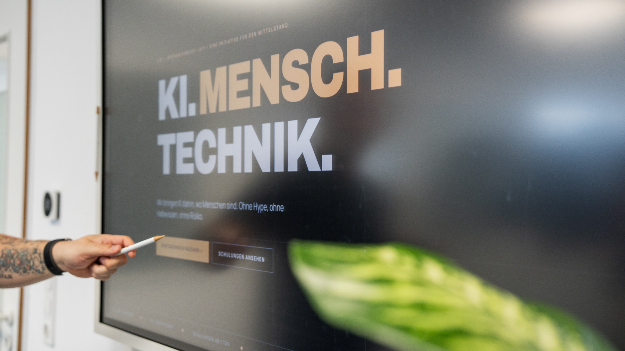 Stephan Kindler erklärt die OMG-KI-Landingpage am Display im OIT-Büro Osnabrück — Schulungsbeispiel KI für den Mittelstand.