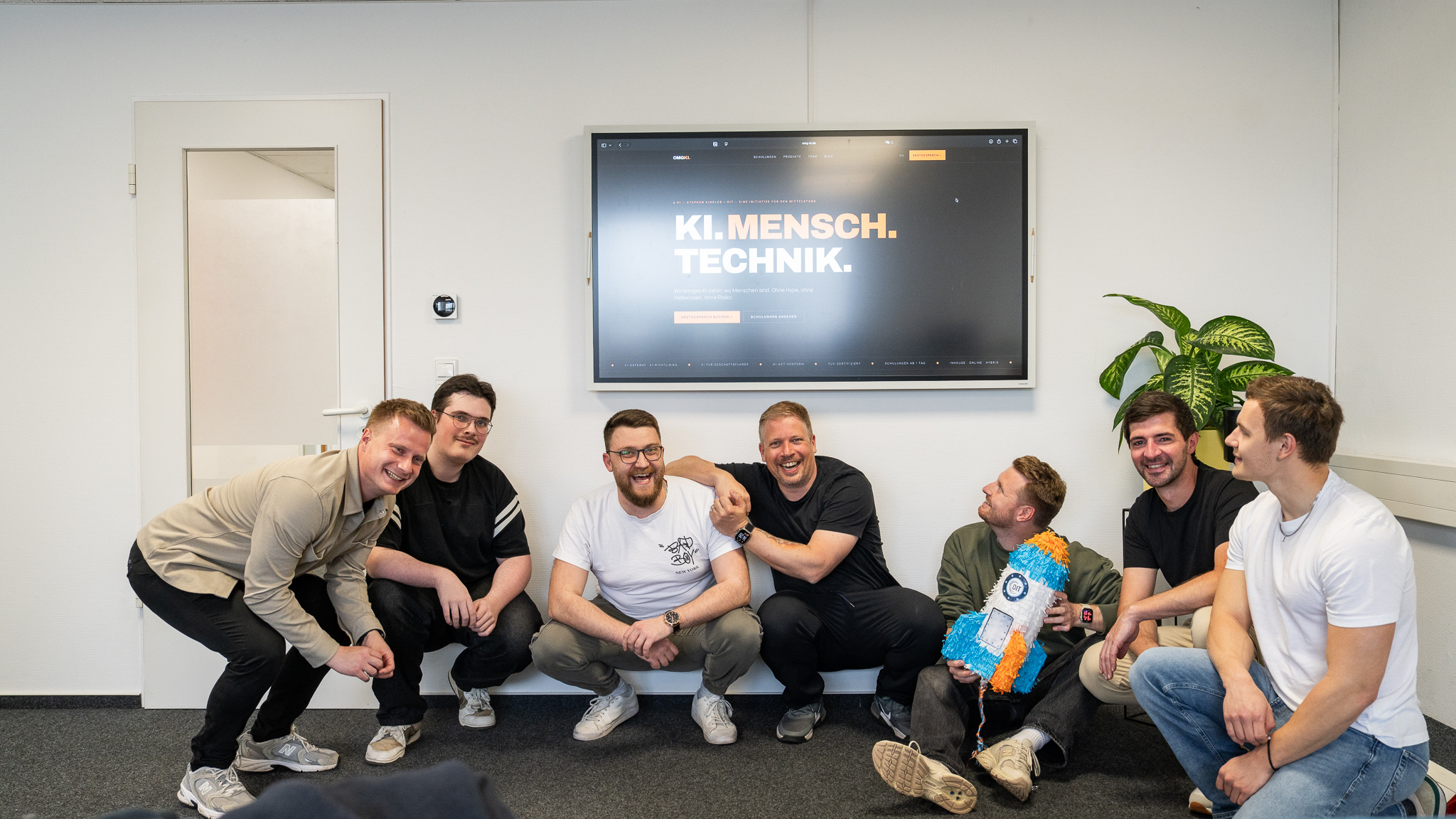 Sieben für KI — Mai 2026, im OIT-Büro Osnabrück. Mit der OIT-Rakete.